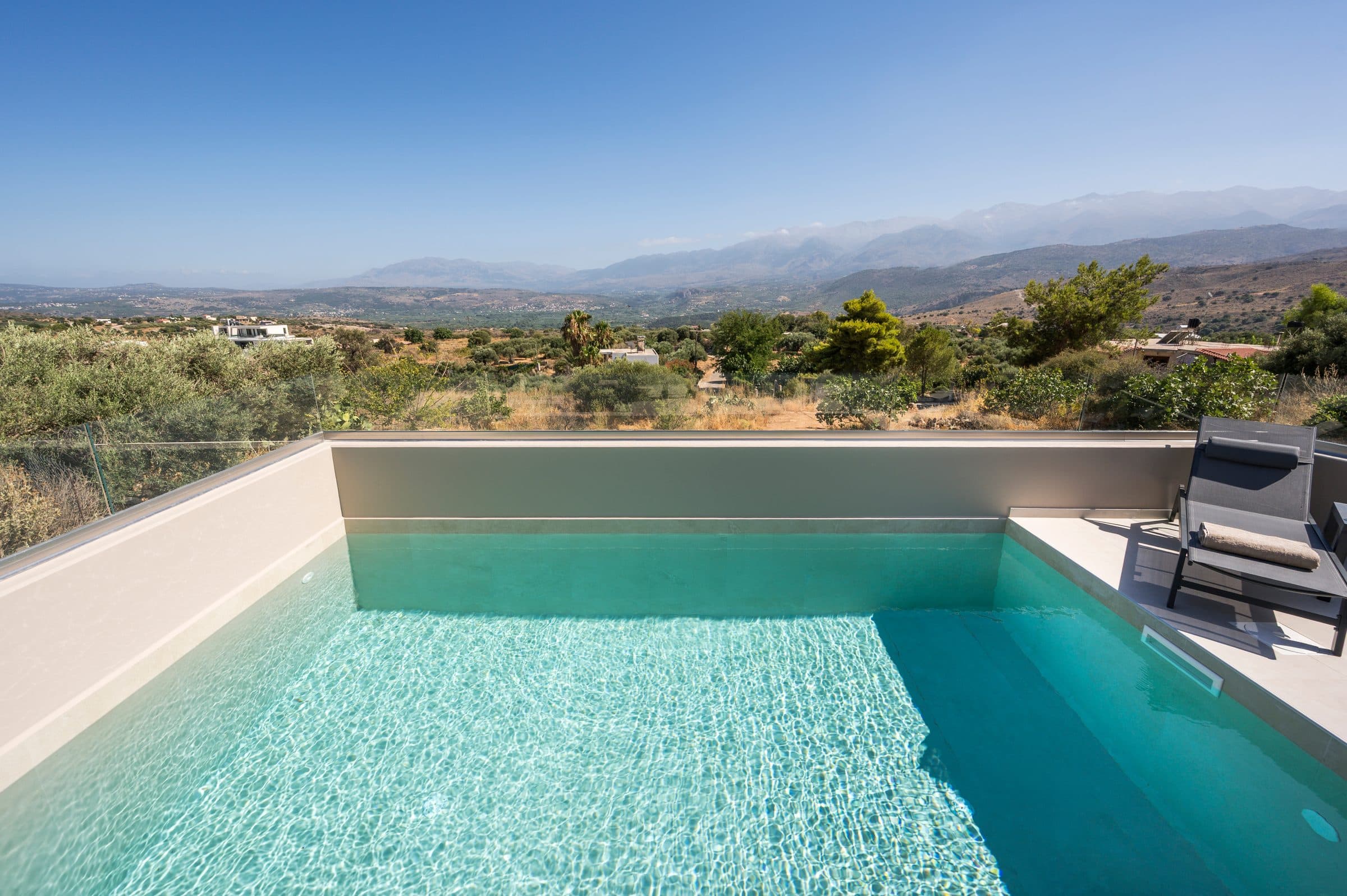 The pool looking out over olive groves towards the hazy peaks of the White Mountains