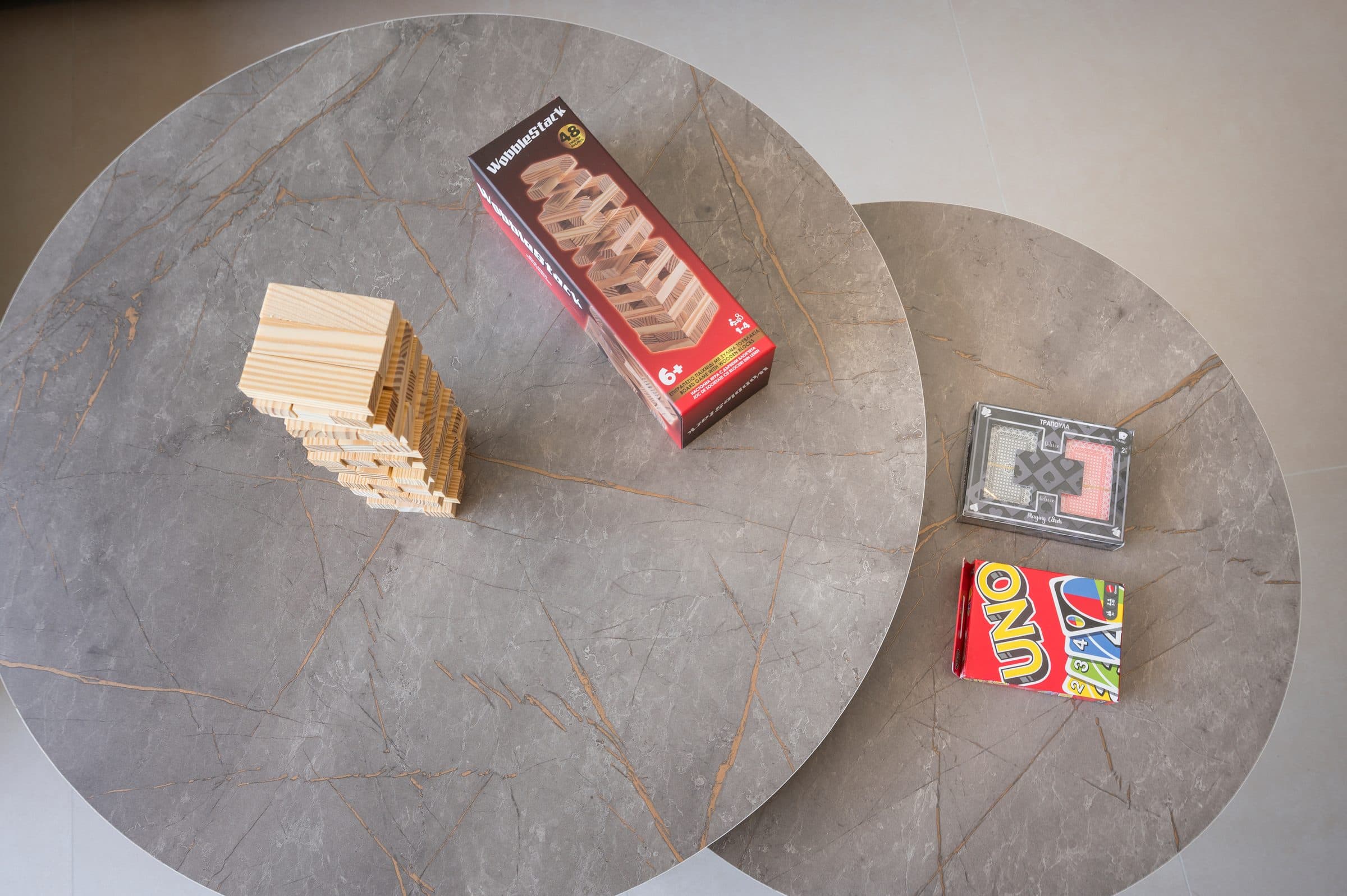 Board games and playing cards laid out on the marble nesting coffee tables in the living room